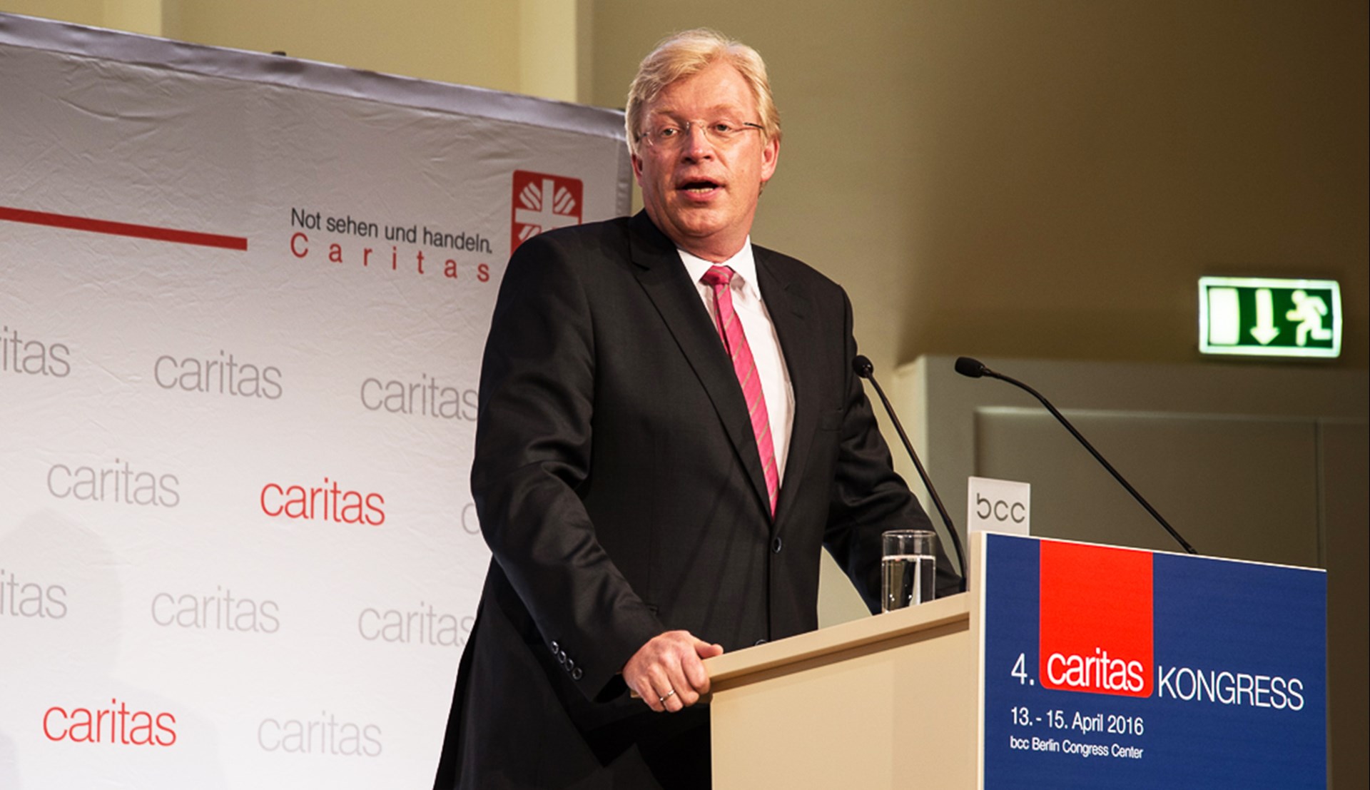 Mann in Anzug mit Krawatte spricht am Rednerpult auf dem Caritas Kongress 2016.