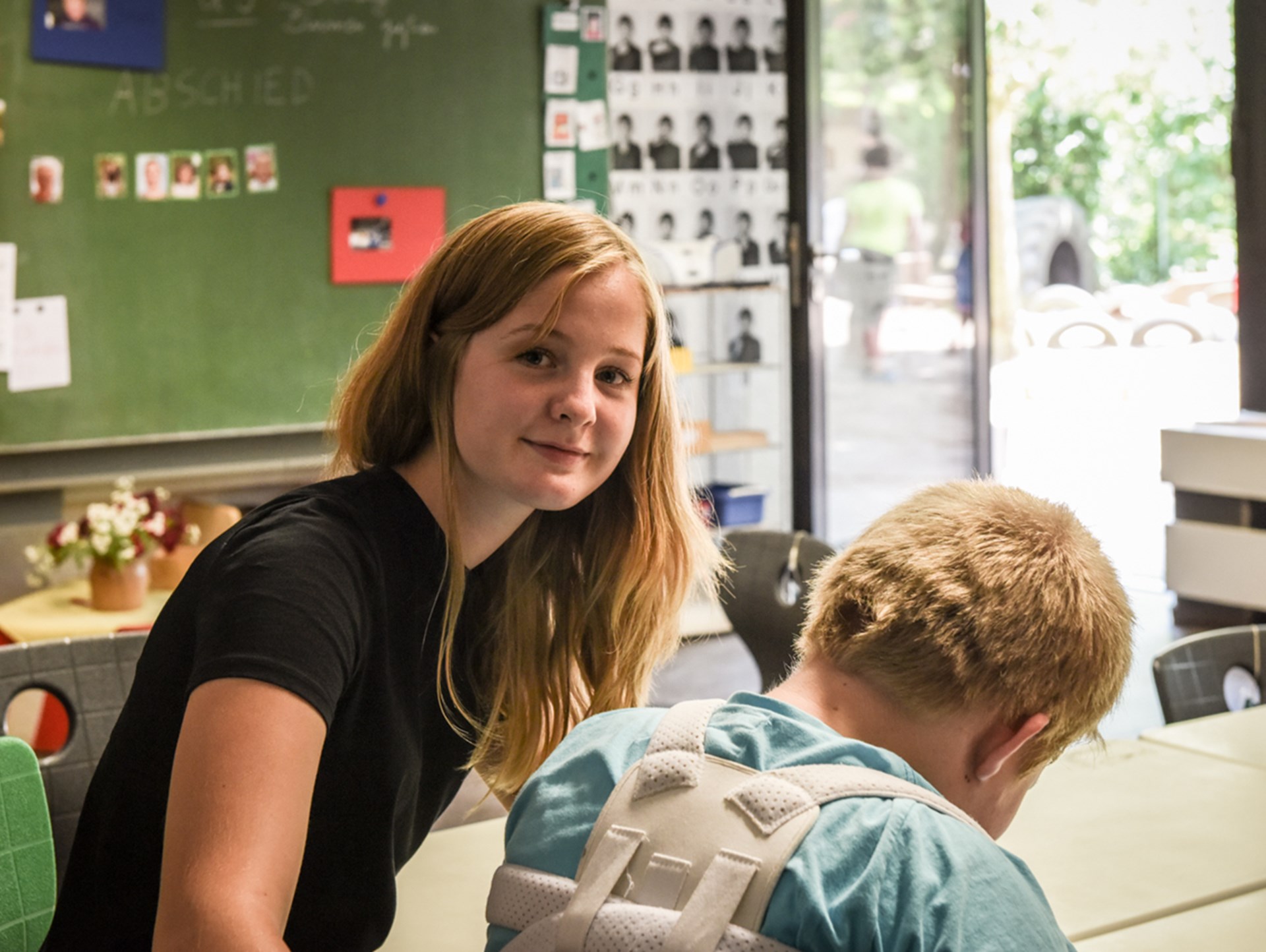 Eine junge Frau sitzt neben einen blonden Jungen