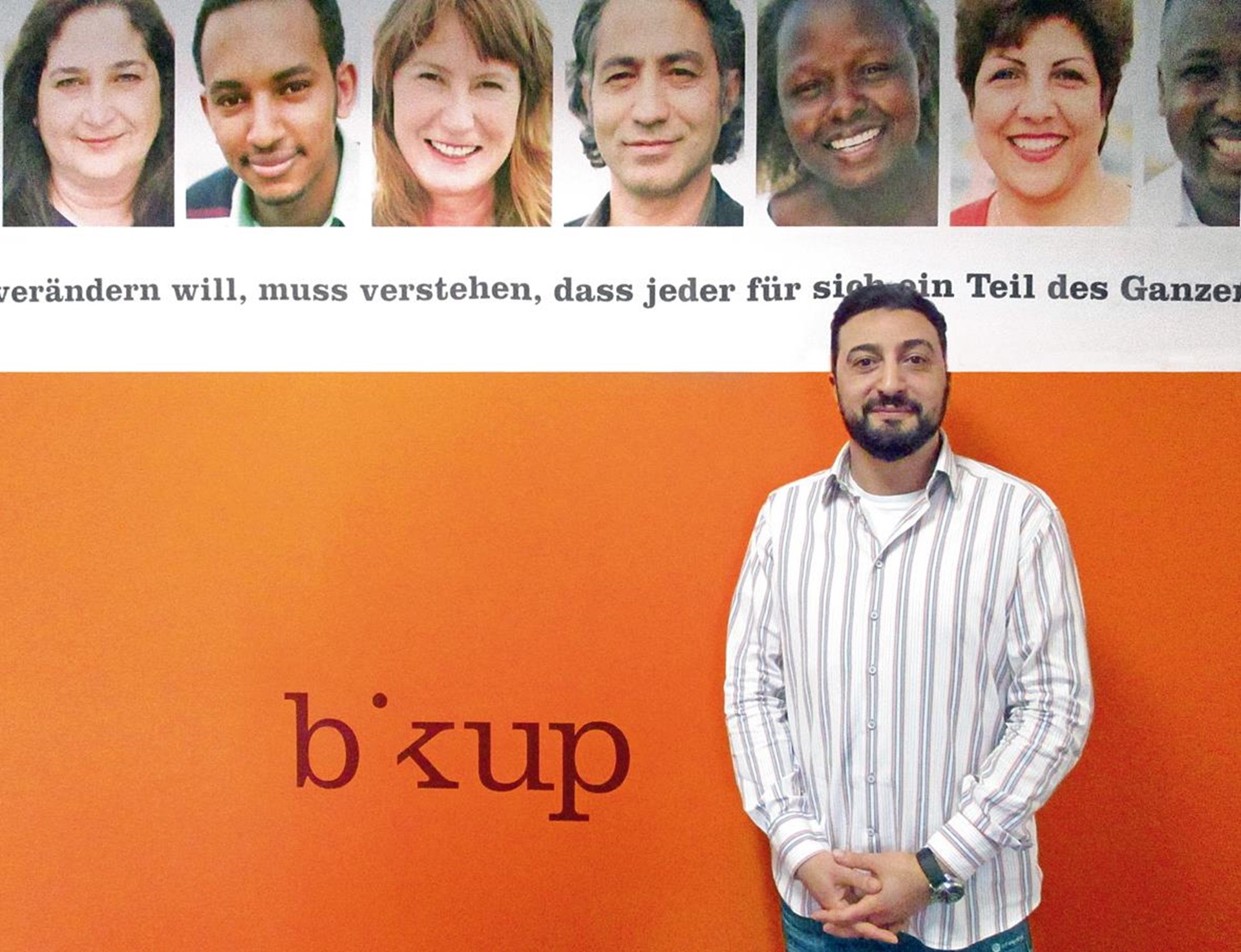Mann im Porträt vor orangener Wand.