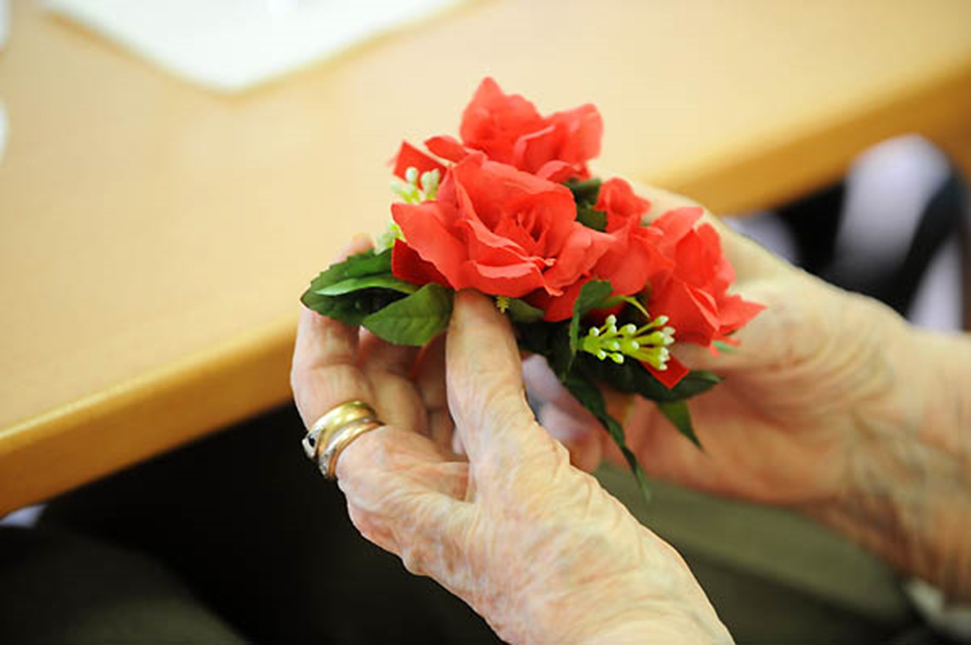 Blumen in der Hand eines alten Menschen