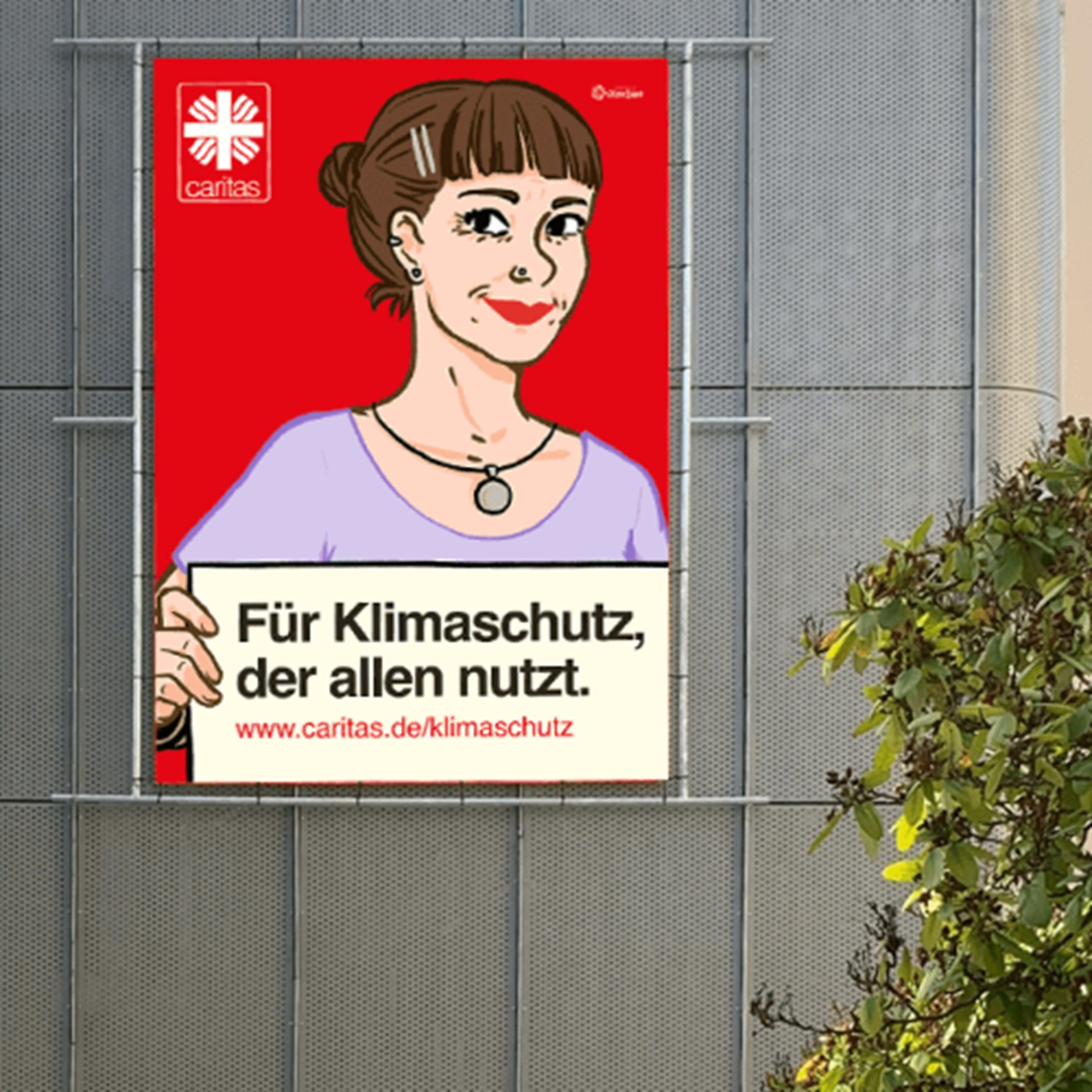 Plakat an einer Gebäudewand, auf der eine junge Frau ein Schild hochhält, auf dem steht: "Für Klimaschutz, der allen nutzt"