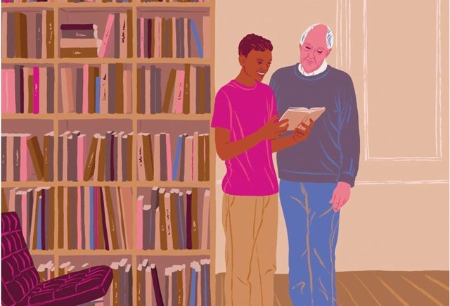 Der Ehrenamtliche und sein Schützling an einem großen Bücherregal.