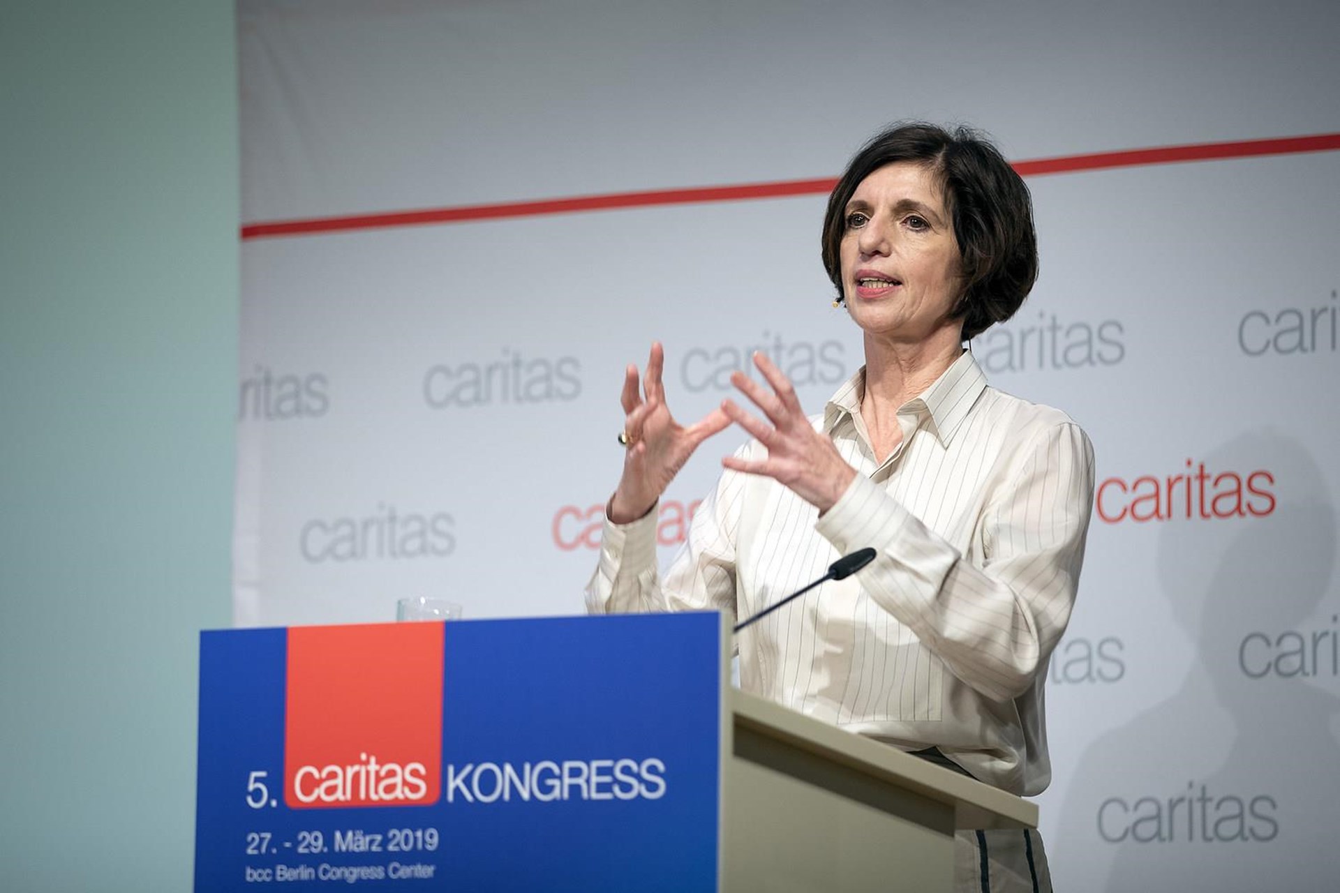 Frau spricht am Rednerpult beim 5. Caritas Kongress, 27.-29. März 2019, mit gestikulierenden Händen.