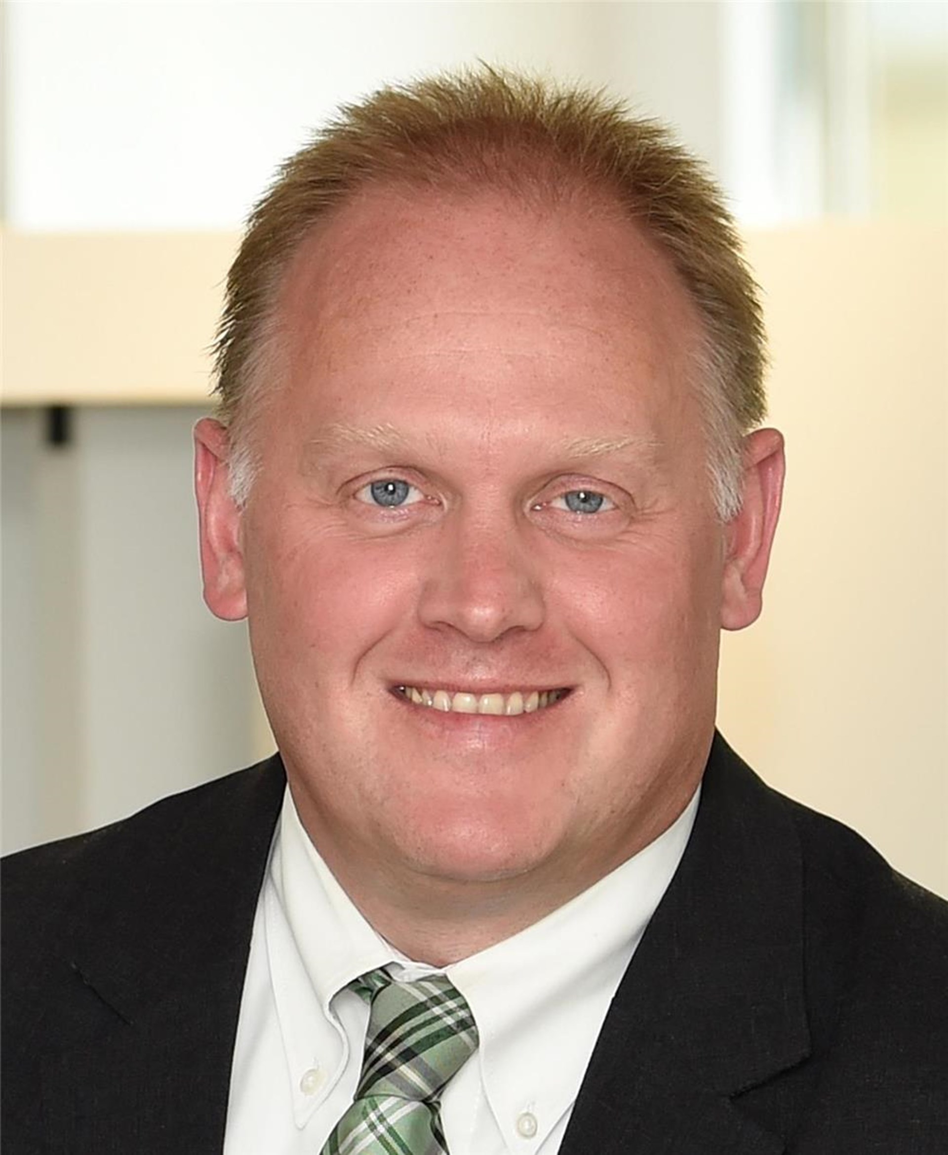 Ein Mann in Anzug und Krawatte lächelt