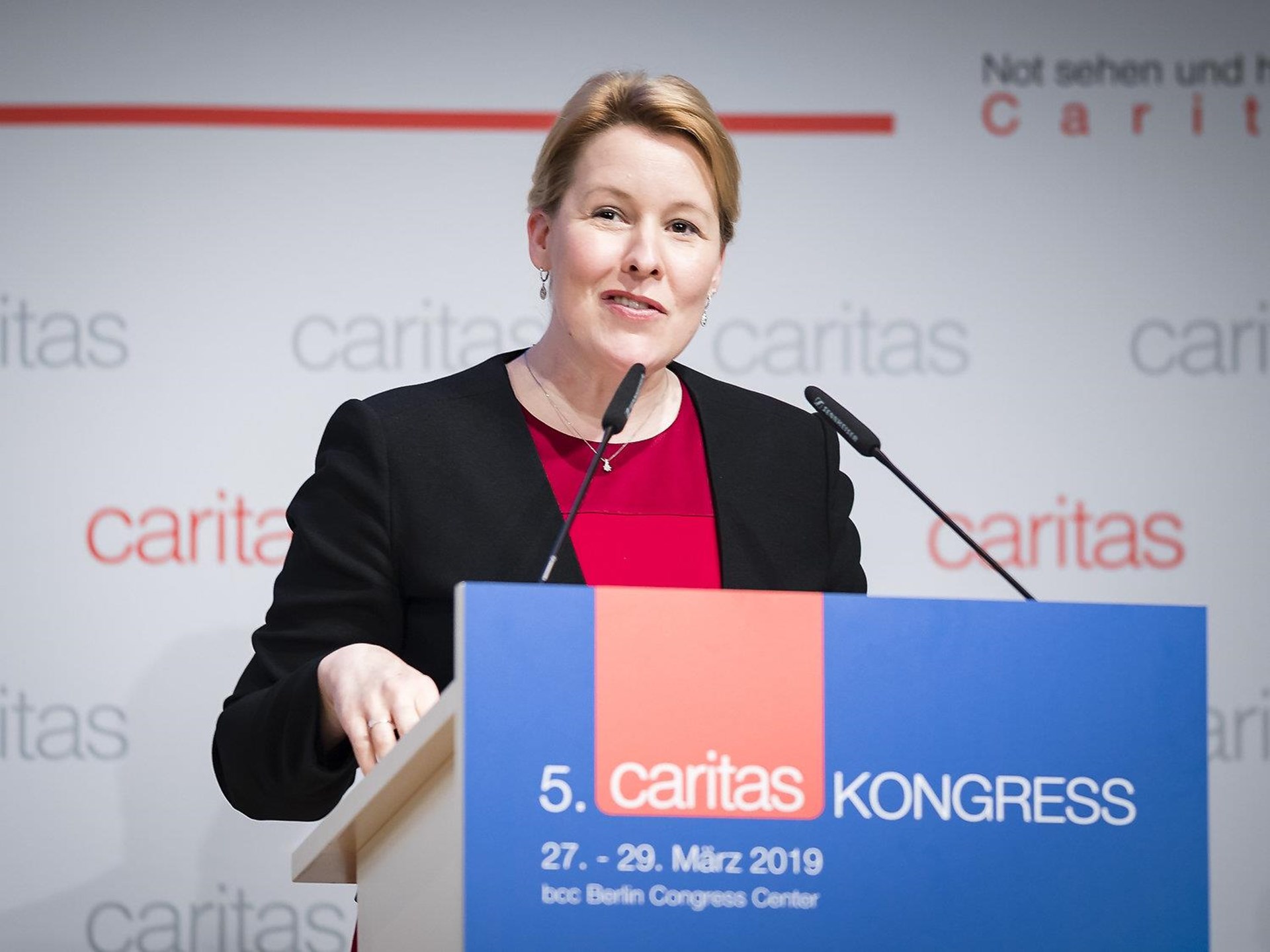 Frau am Rednerpult beim 5. Caritas Kongress 2019 in Berlin, trägt schwarze Jacke und spricht ins Mikrofon.