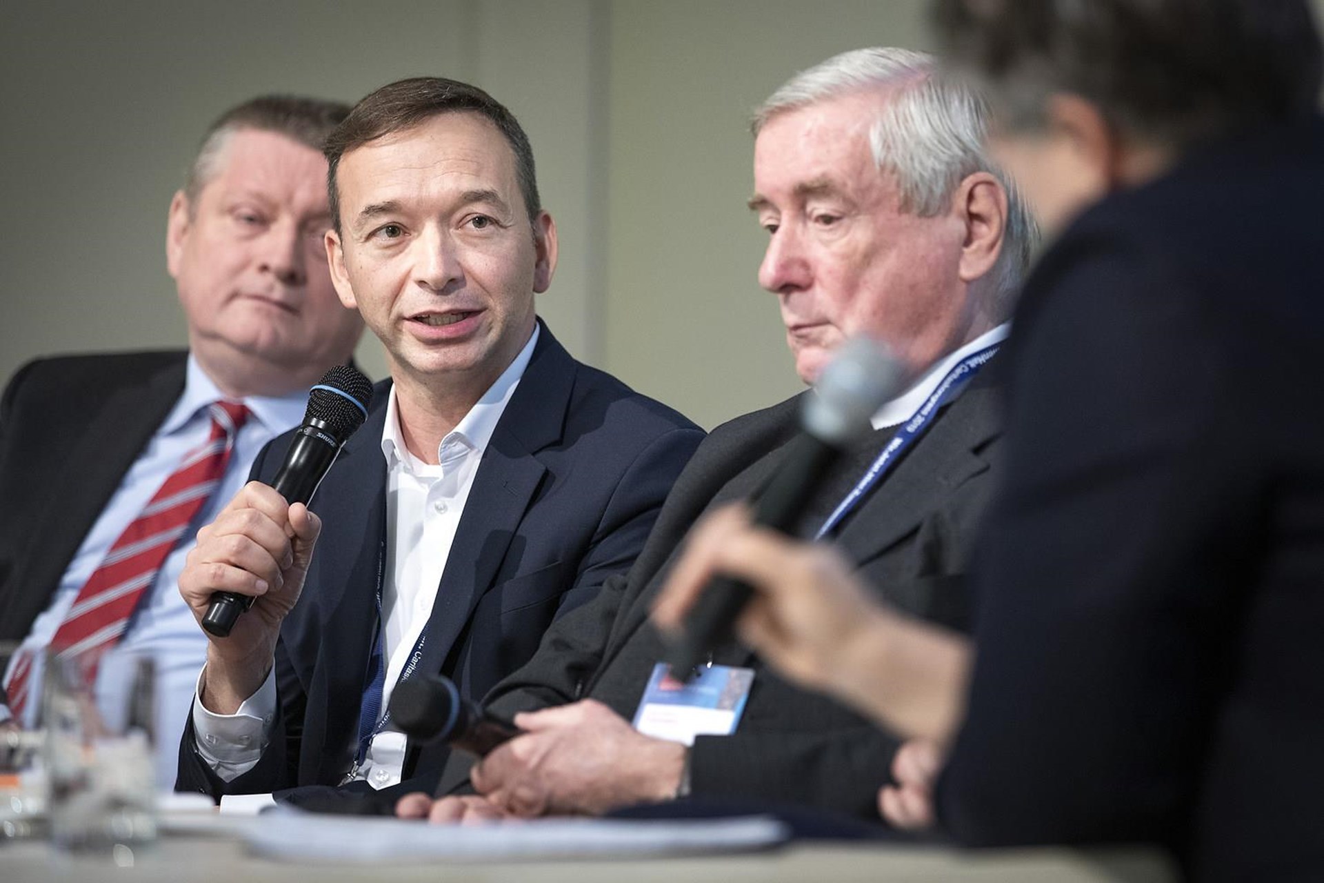 Männer diskutieren auf dem Podium