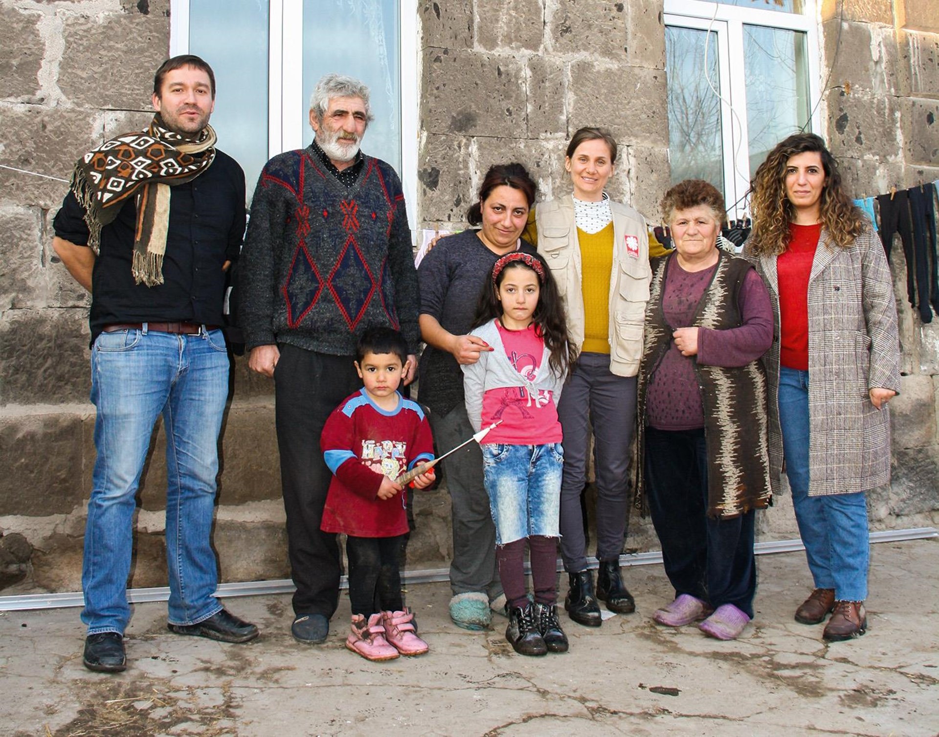 Gruppenbild vor einem Haus in Armenien, das Solarmodule auf dem Dach hat