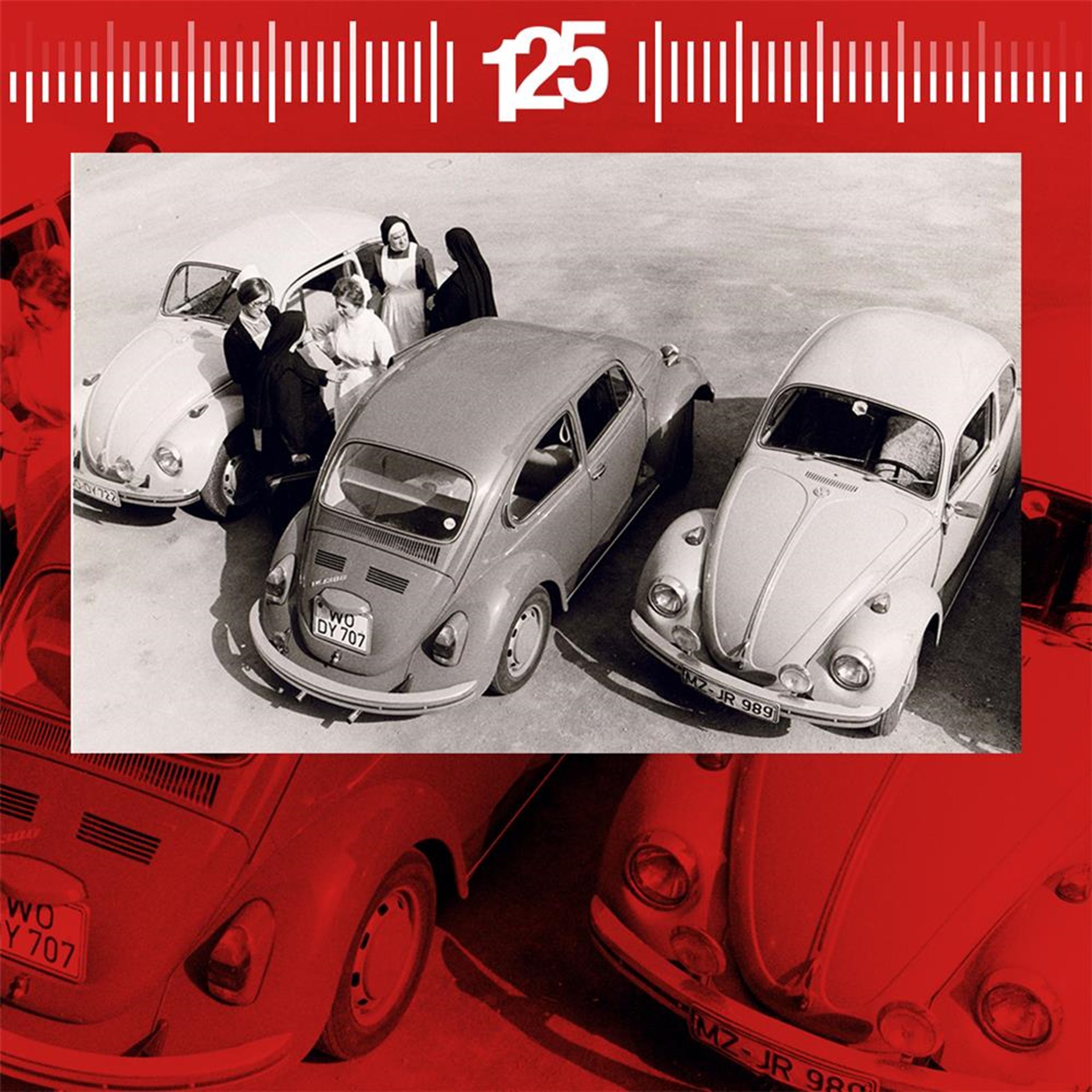 Schwarz-weiß Foto von drei Volkswagen Käfern, mit einer Gruppe von Personen im Hintergrund. Die Autos sind in einer Parkposition angeordnet, während eine Maßstabsskala oben im Bild sichtbar ist.
