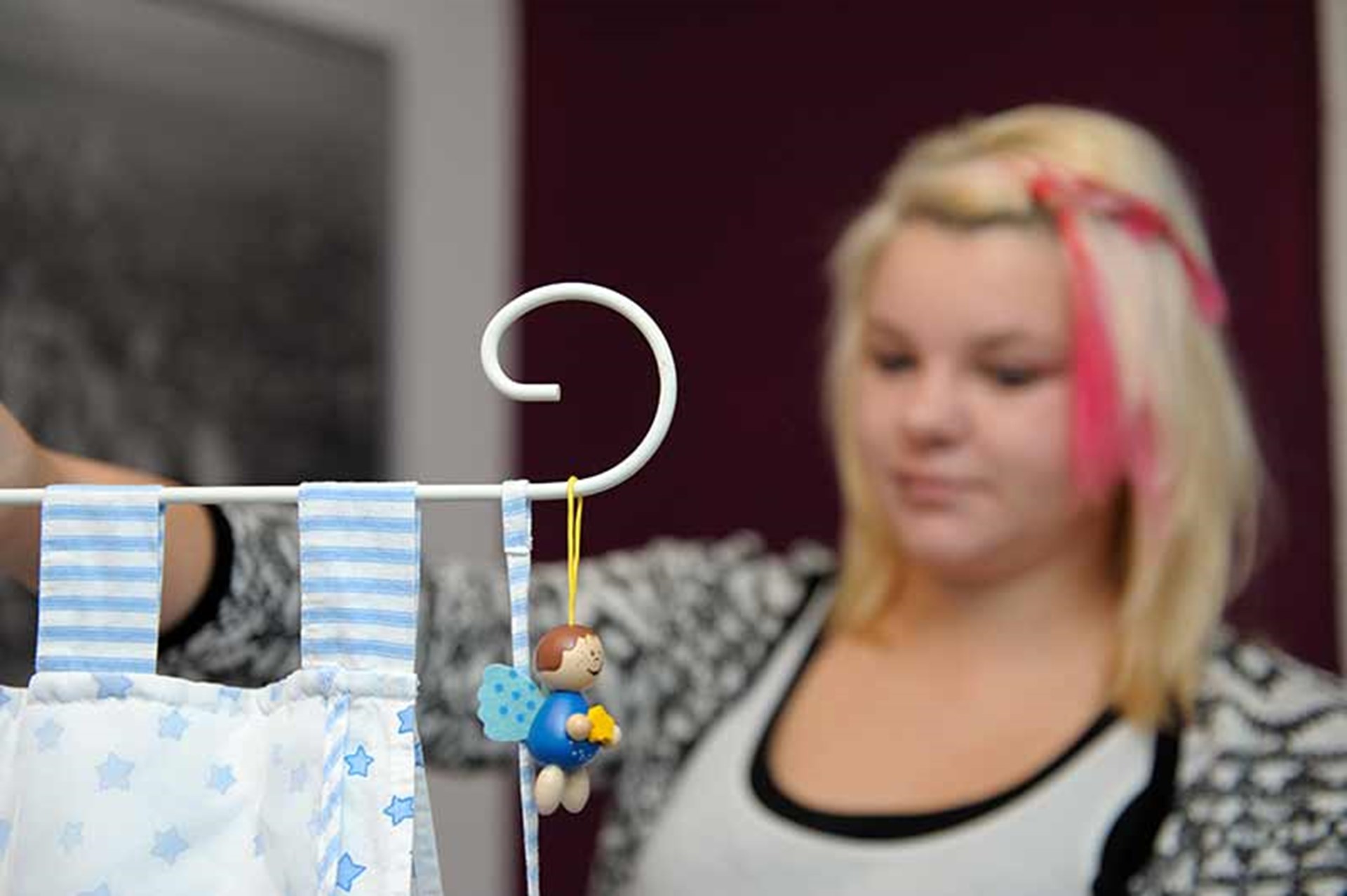 Junge Frau vor Babybett
