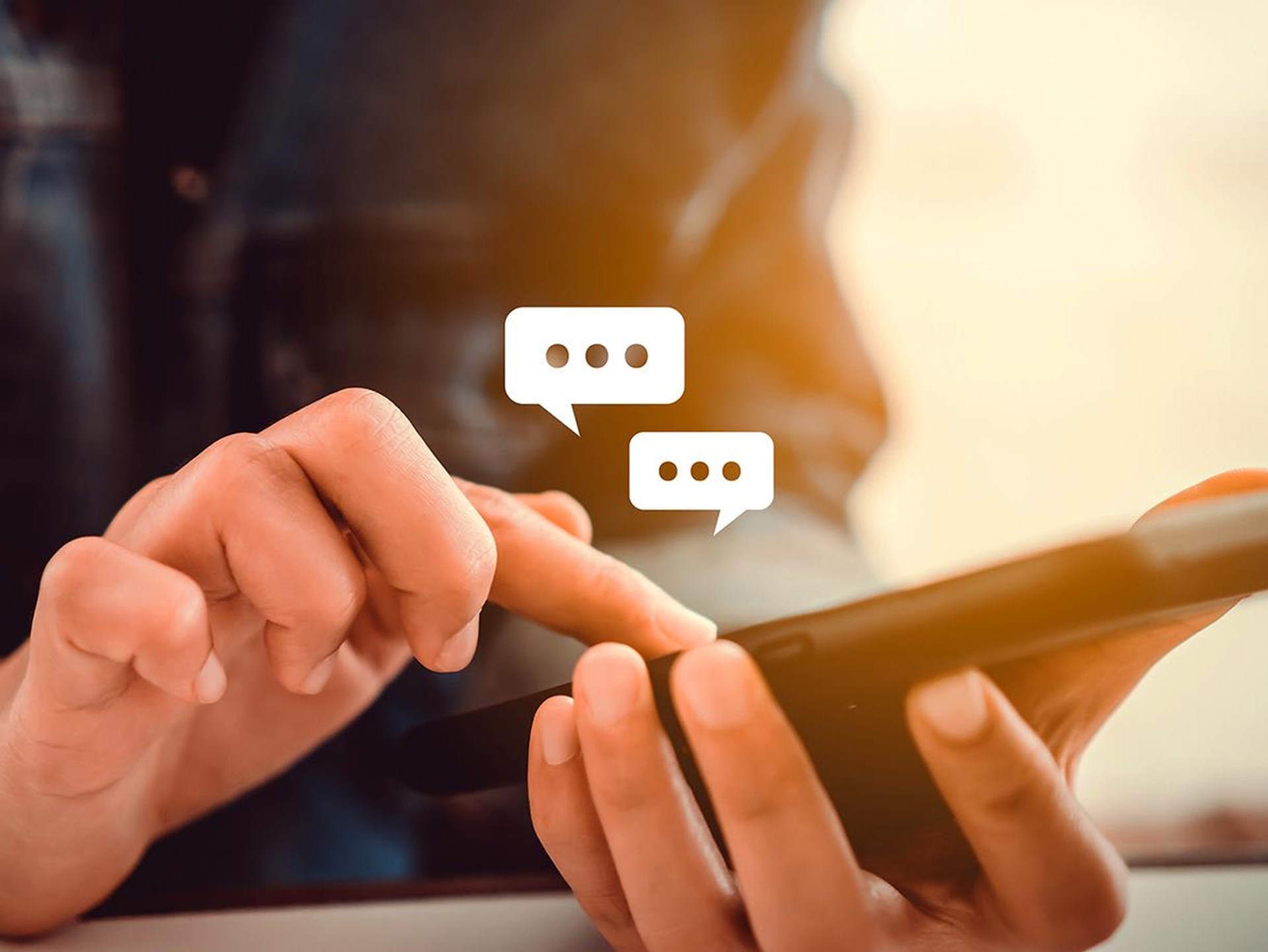 Eine Person tippt auf einem Smartphone, während Sprechblasen über dem Gerät schweben, was auf eine Messaging-App hinweist.