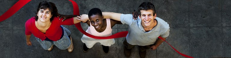 Zwei Frauen und ein Mann, verbunden durch ein rotes Band