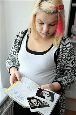 Junge Schwangere mit Mutterpass