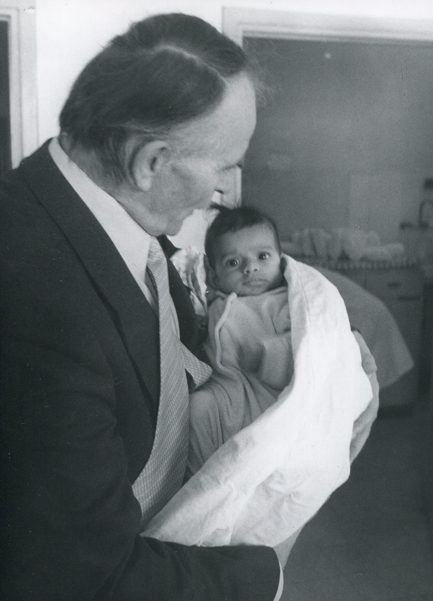 Ernst Schnydrig hält ein Baby in der Hand