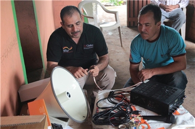 Zwei Mitarbeiter der Caritas El Salvador installieren eine Funkstation.
