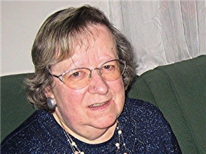 Portrait einer älteren Dame mit Brille und in dunkler Bluse.