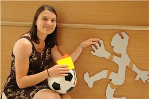 Frau mit Fußball in der Hand und Männchen mit Handicaps