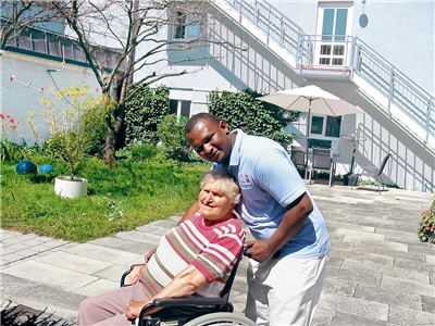 Krankenpfleger mit alter Frau im Rollstuhl