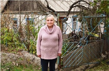 Die 66-jährige Binnenvertriebene Antonia Pawlow vor ihrem neuen Zuhause, einem ländlichen älteren Haus.