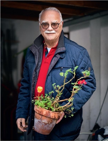 Hans-Jürgen Fischer mit einer Topfpflanze in der Hand.