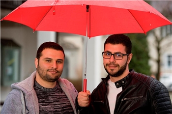 Zwei syrische Männer mit Regenschirm