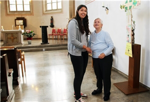 Auf dem Bild steht eine jüngere und eine ältere Frau in einer Kirche