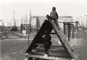 Kinder spielen auf einem bescheidenen Spielplatz mit Holzgeräten im Wohngebiet Folsterhöhe