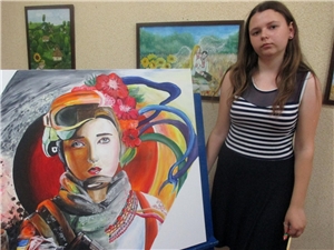 Katja mit einem ihrer Bilder, das eine moderne ukrainische Frau porträtiert.