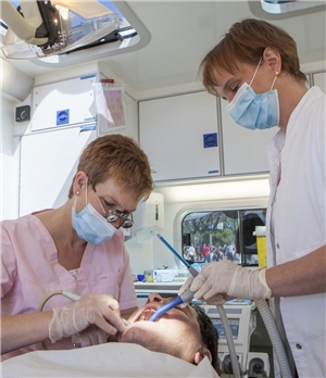 Im Zahnmobil für obdachlose Menschen: Eine Zahnärztin und ihre Assistentin betreuen ehrenamtlich einen Patienten.