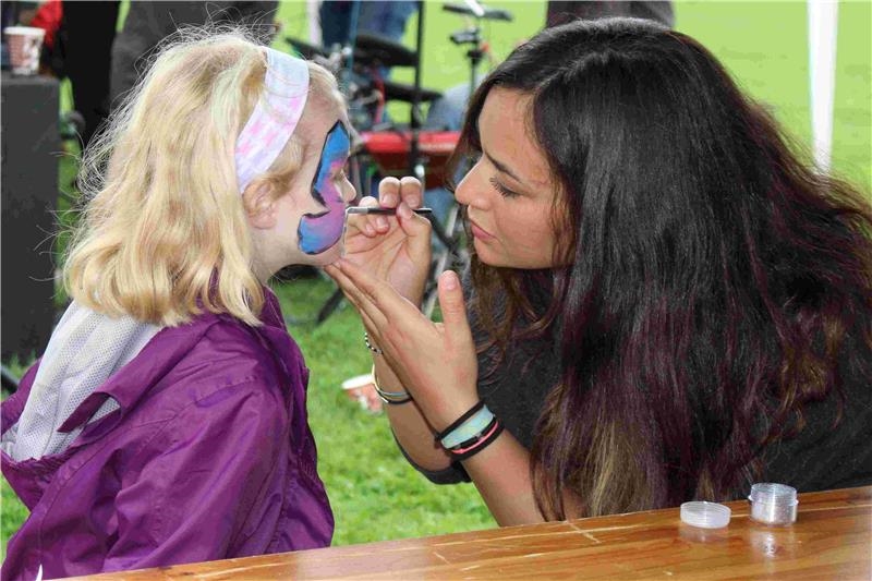 Eine junge Helferin schminkt einem Mädchen phantasievoll das Gesicht. (Marco Wagner, Caritasverband Koblenz)